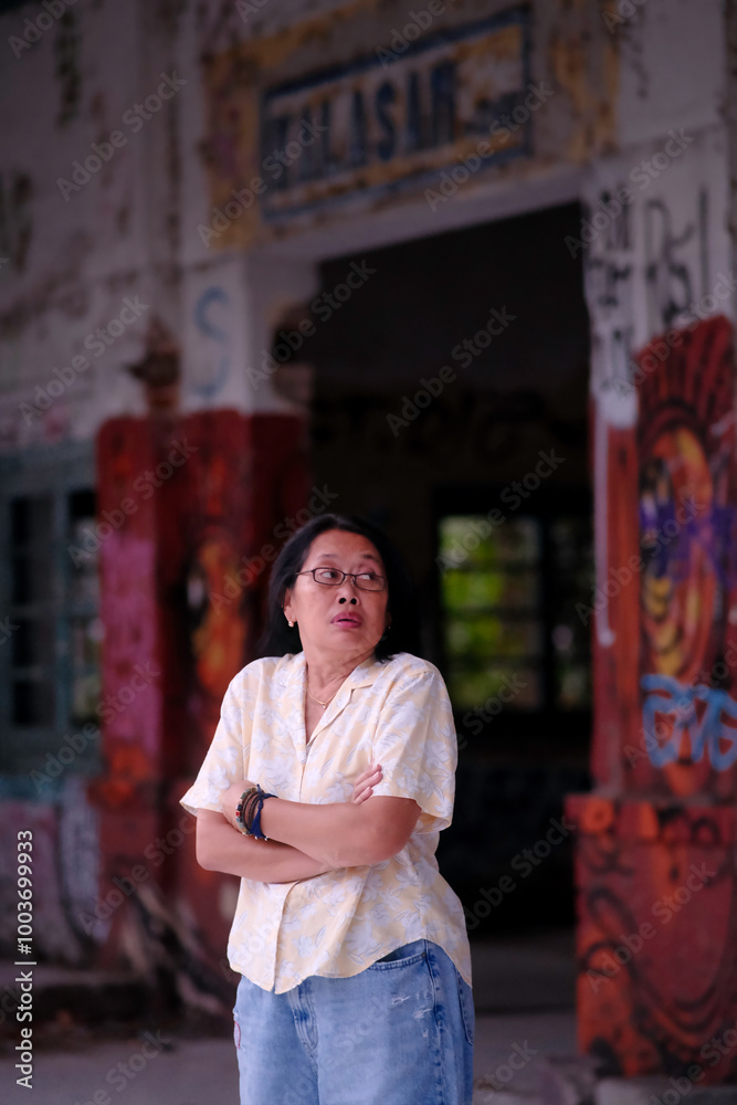 Naklejka premium A woman with a scared expression is standing in an abandoned, creepy train station