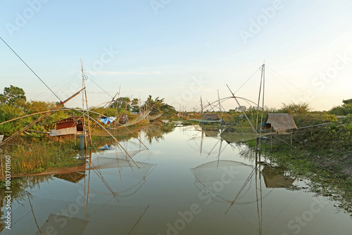 Red lotus lake, Udon Thani, Yisan, Thailand - October 17, 2019: Sunset view of traditional fishingnets besides lake  photo