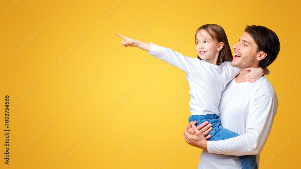 Excited cute little girl pointing her daddy at copy space over yellow background, family offer, discounts for kids Excited cute little girl pointing her daddy at copy space over yellow background, family offer, discounts for kids