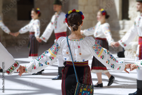 Dancers dancing and wearing one of the traditional folk costume from Romania photo