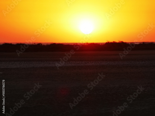 Dull sundown, stuffy air. Sunset over the saltpan lake after a sultry day, dull orange light due to the high humidity