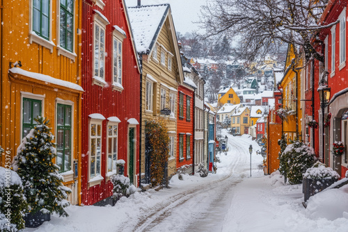 Snow is falling on a street lined with colorful wooden houses decorated for christmas in Norway