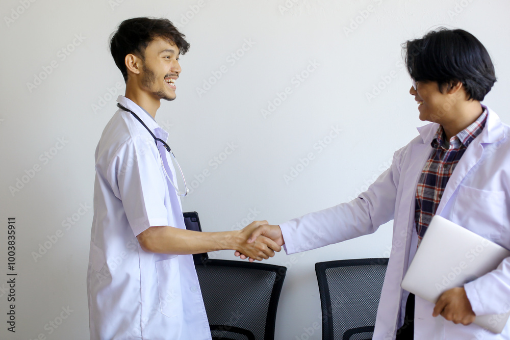 Obraz premium Two Asian Medical Students Shaking Hands At Hospital