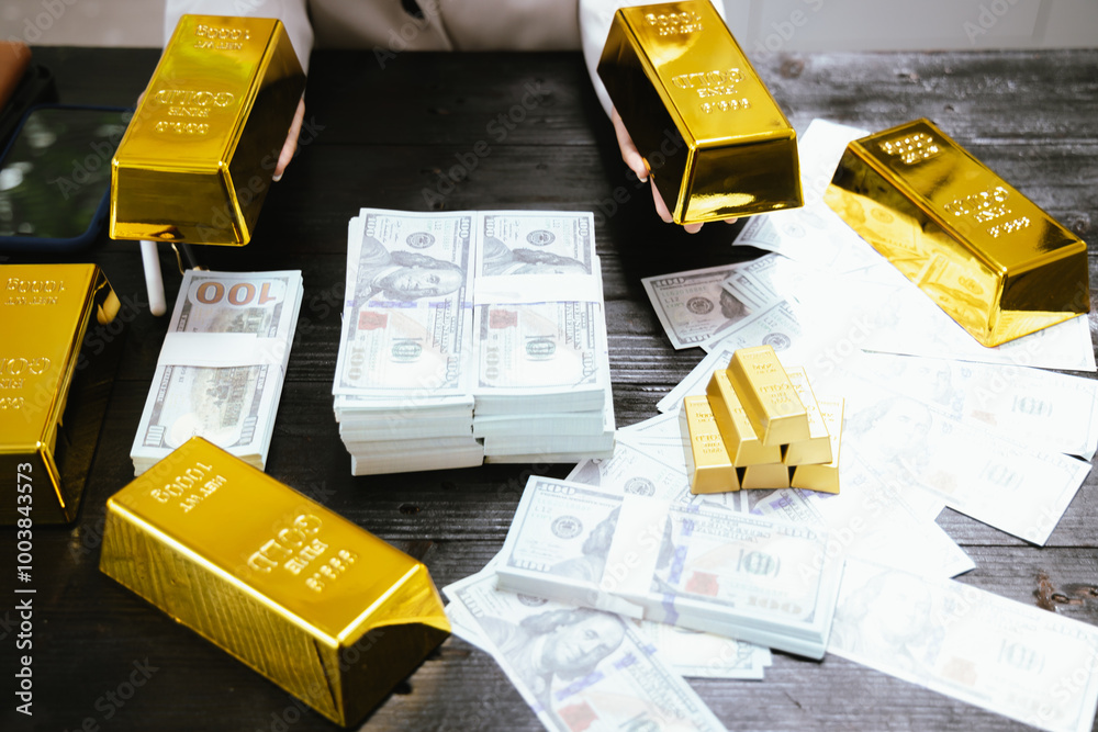 Gold bars and silver on table, Asian businesswoman at desk in office Gold bars and silver on table, Asian businesswoman at desk in office