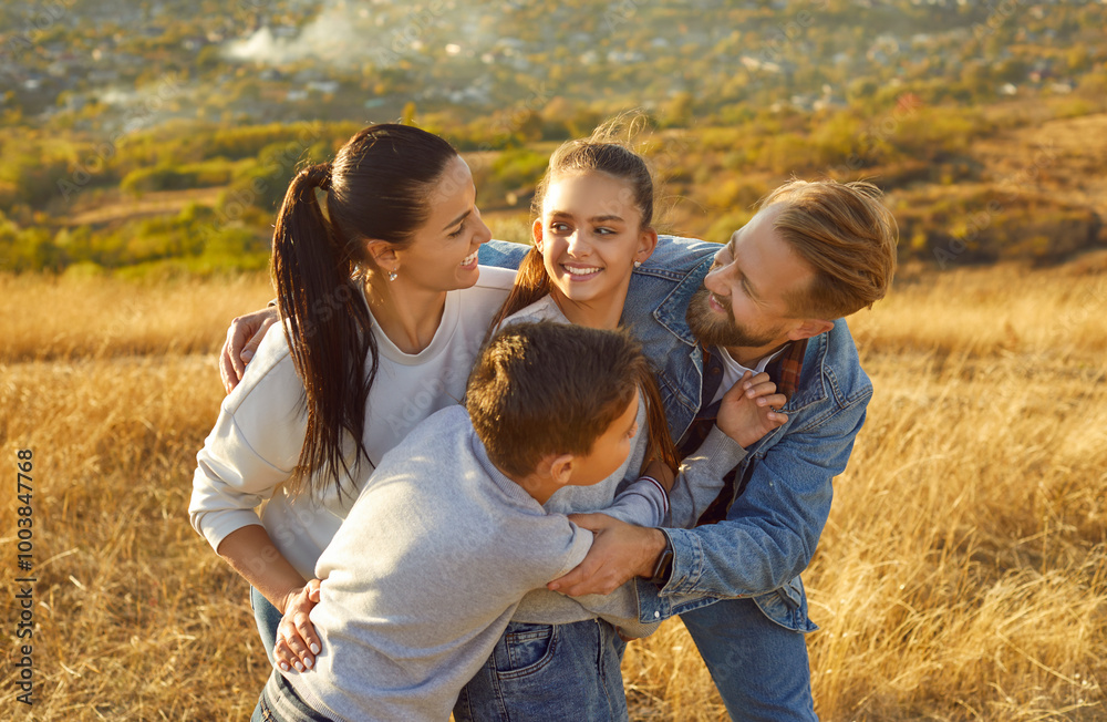Family with children having a fun time, walking outdoors, strolling in nature during the weekend or vacation. They hug, smile, and enjoy each other company, making the most of leisure time together. Family with children having a fun time, walking outdoors, strolling in nature during the weekend or vacation. They hug, smile, and enjoy each other company, making the most of leisure time together.