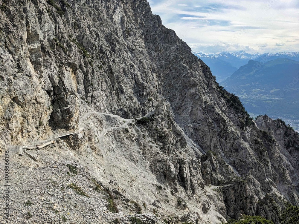 Enjoy a stunning panoramic view of the Rocky Cliffside, well contrasted by majestic mountains, inspiring outdoor adventure seekers