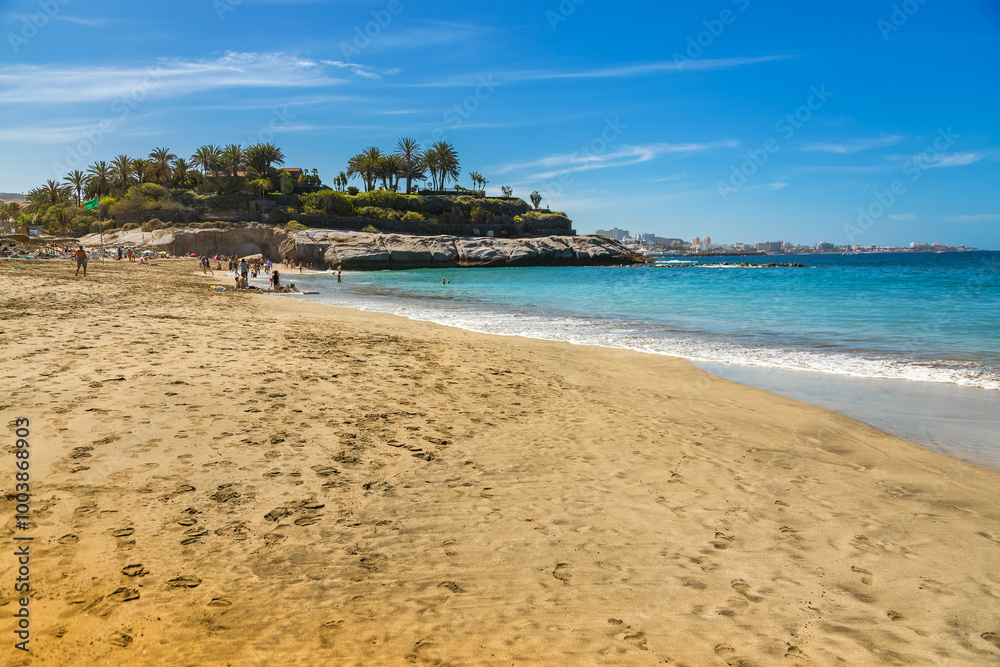 A breathtaking view of Playa Del Duque in Tenerife, where clear blue waters and soft golden sand meet A breathtaking view of Playa Del Duque in Tenerife, where clear blue waters and soft golden sand meet