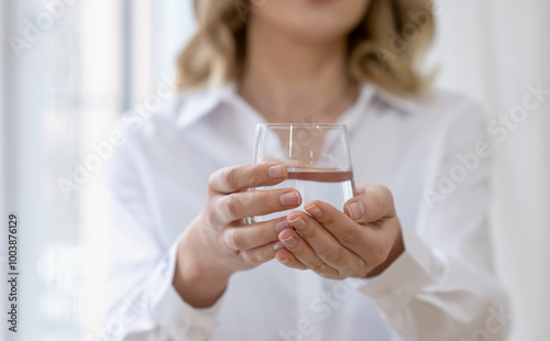 Woman holds a glass of water in her hands. Selective focus, Close Up