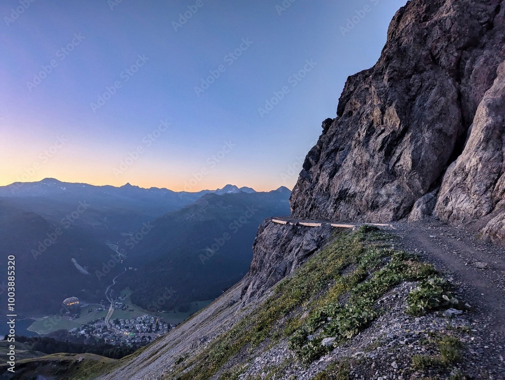 Fototapeta premium A winding dirt road rising steeply along the side of a mountain