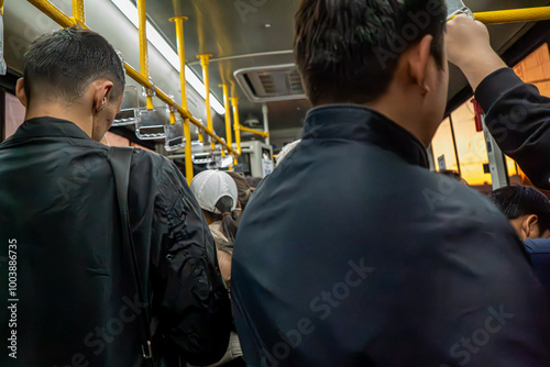 This candid photograph captures a typical day during a subway commute, with a crowd of passengers standing shoulder to shoulder. The image highlights the packed nature of public transportation 