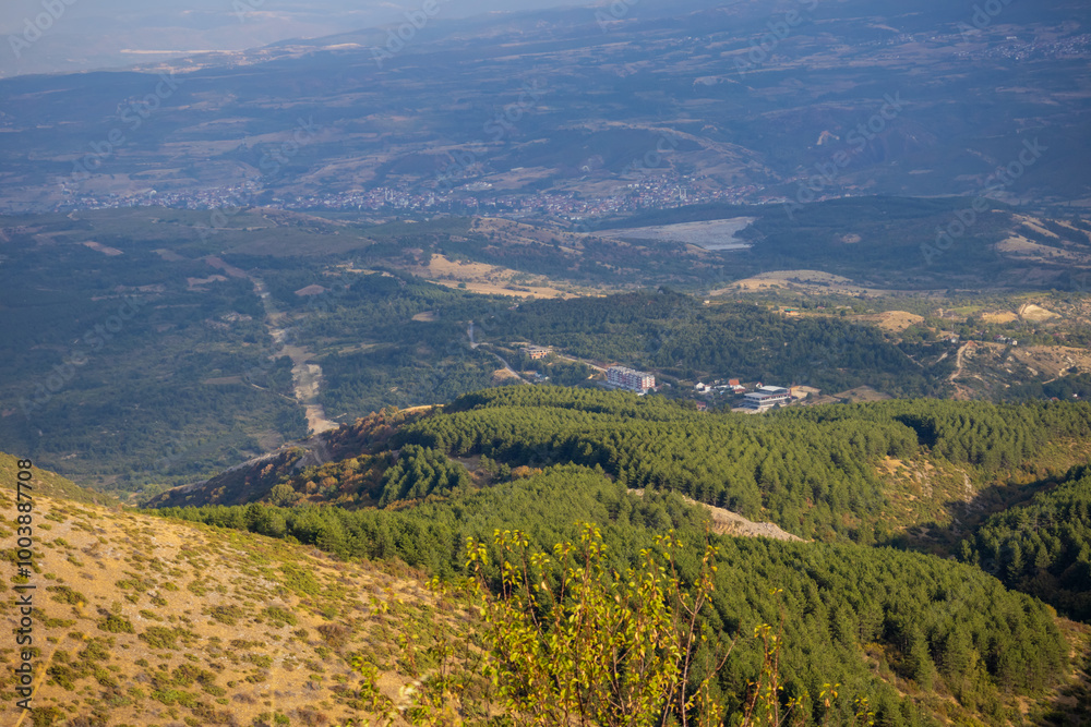Fototapeta premium Dramatic cityscape panorama overlooking green hills