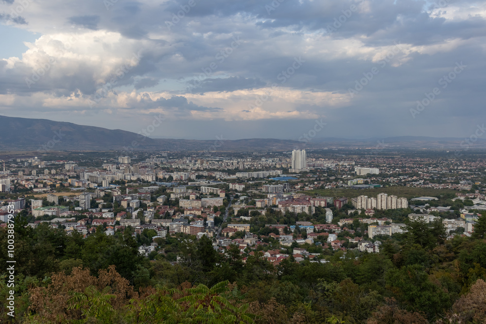 Naklejka premium Dramatic cityscape panorama overlooking green hills
