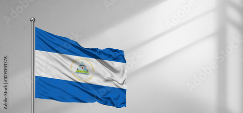 Nicaragua national flag cloth fabric waving on beautiful window light grey Background. photo