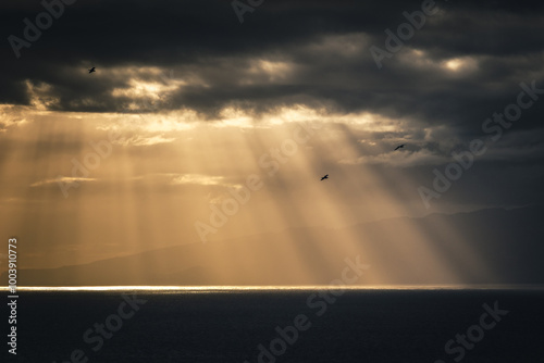 Obraz na płótnie The sun's rays break through the clouds and create a beautiful atmosphere - the island of La Gomera in the background. w salonie