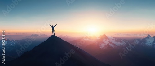 Person celebrating on mountain peak at sunrise with open arms against scenic backdrop of mountains.