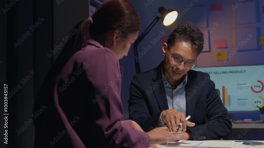Business colleagues analyzing financial data and strategizing on a project during overtime hours at the office Business colleagues analyzing financial data and strategizing on a project during overtime hours at the office