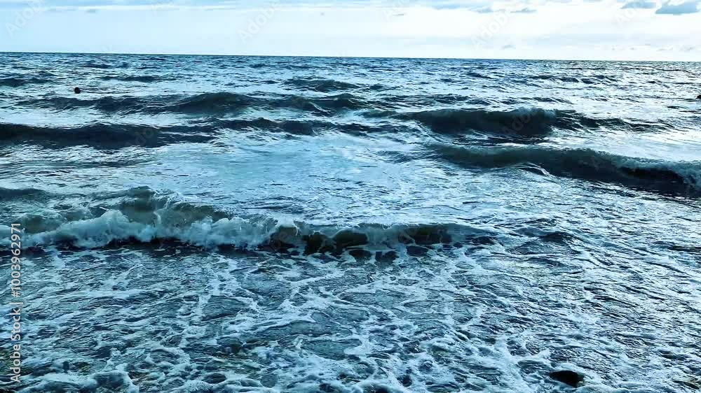 Beautiful Foaming Waves in the Ocean Blue Sky Clouds Beach Close Up Slow Motion. Waves in the Sea and Sky on a Sunny Summer Day Close-Up, Relax Beauty Vacation Travel Planet Nobody Background. Beautiful Foaming Waves in the Ocean Blue Sky Clouds Beach Close Up Slow Motion. Waves in the Sea and Sky on a Sunny Summer Day Close-Up, Relax Beauty Vacation Travel Planet Nobody Background.