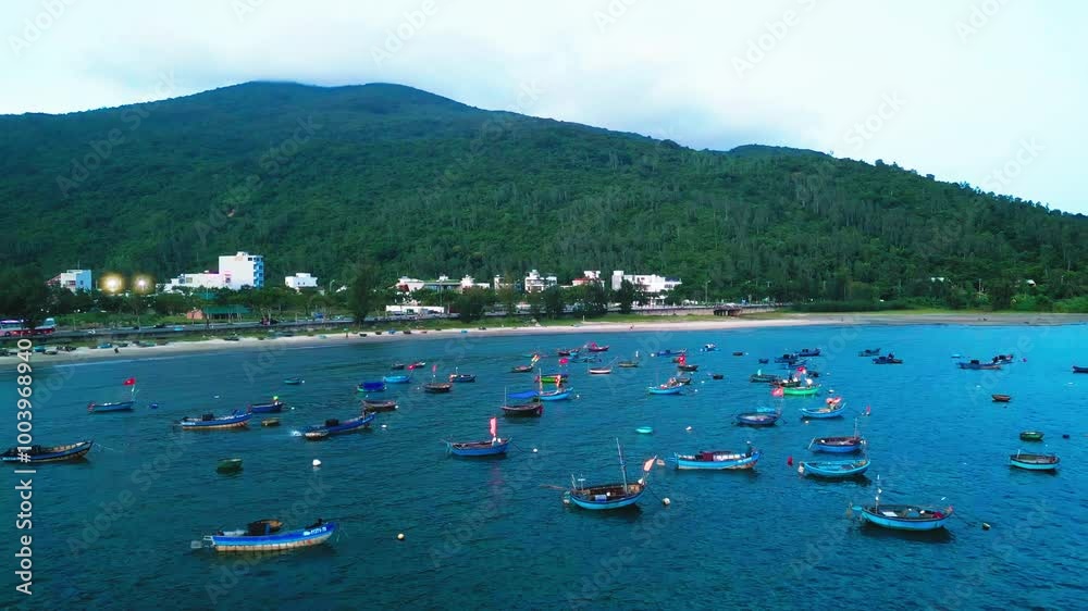 A drone shot of beach water with boats floating near the mountain A drone shot of beach water with boats floating near the mountain