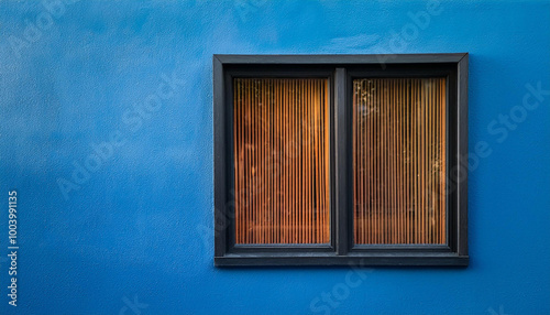 Modern window with a dark wooden frame embedded in vibrant blue stucco wall. Minimalist exterior. photo