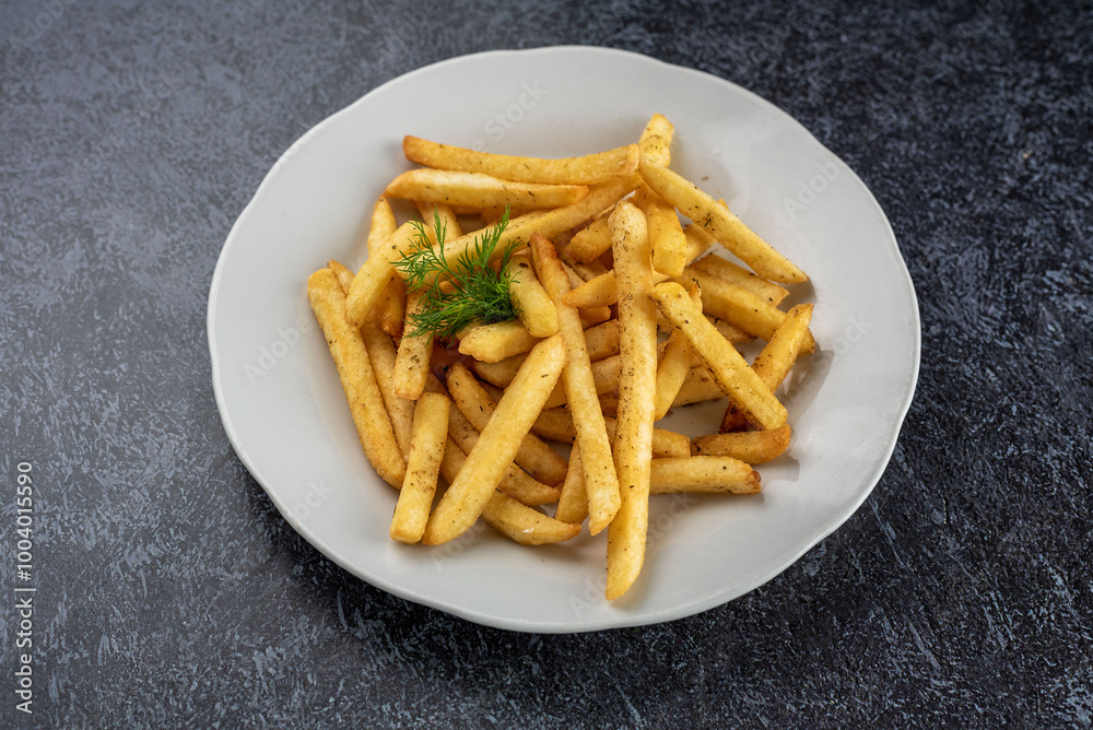A plate of french fries with a parsley leaf on top A plate of french fries with a parsley leaf on top
