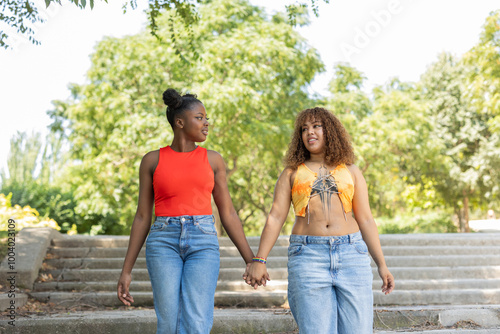 Diverse LGBTQIA+ couple enjoying a walk in the park photo