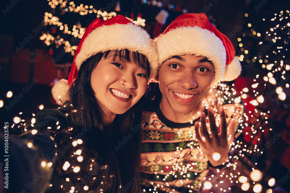 Photo of two young peaceful partners make selfie festive christmas hold illumination decor apartment indoors Photo of two young peaceful partners make selfie festive christmas hold illumination decor apartment indoors