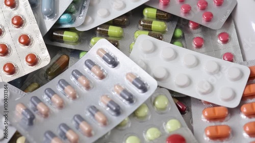 Pills in blisters rotating through shot in an overhead seamless loop