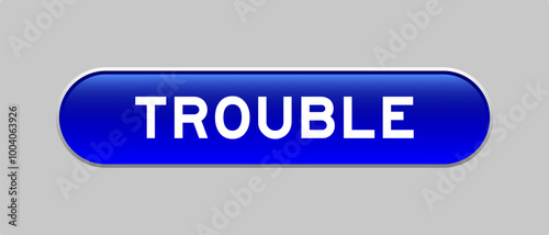 Blue color capsule shape button with word trouble on gray background