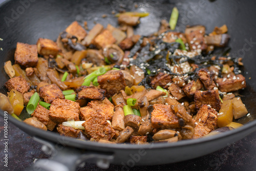 Crispy tofu stir fried in wok along with  mushrooms and  eggplant photo