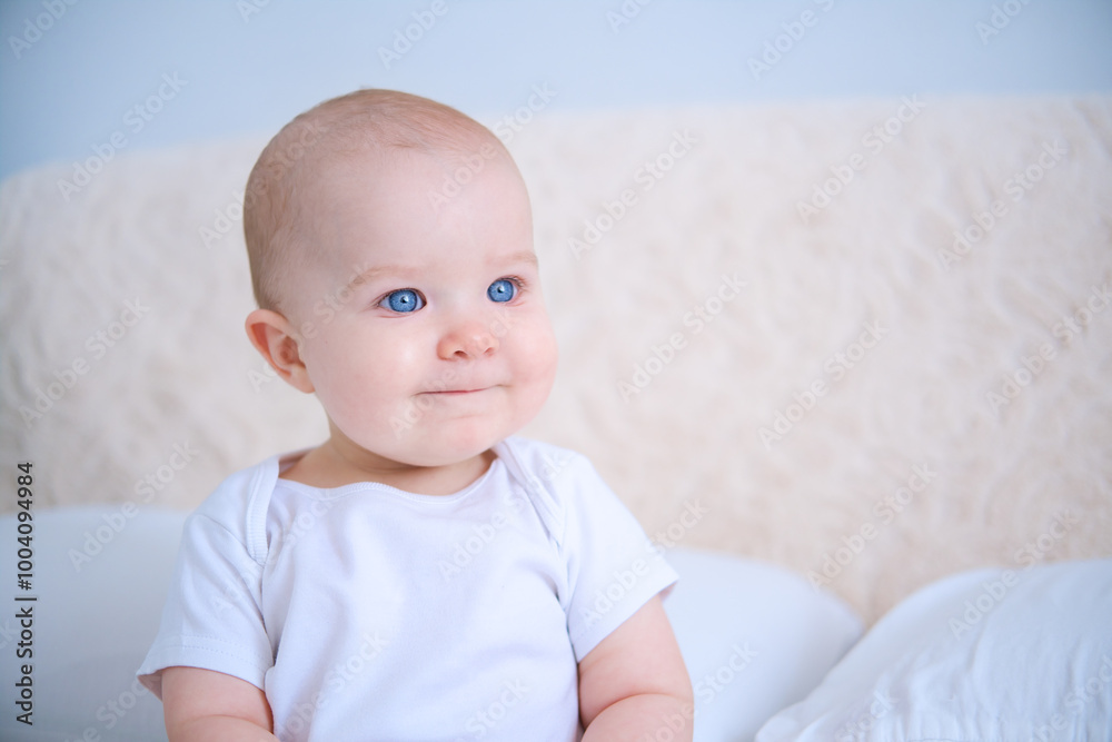 portrait of smiling healthy baby in white bodysuit sitting on bed. copy space portrait of smiling healthy baby in white bodysuit sitting on bed. copy space