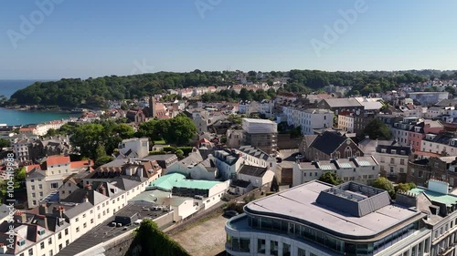 Guernsey,St Peter Port. High drone footage over the roof tops of the town showing the buildings flying south from St James towards St Martins and views to sea and Havelet Bay on bright sunny day photo