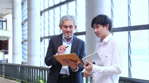 Asian senior professor is giving advice to the college student on the research thesis while sitting in the university faculty for education, academic and business