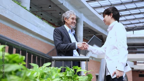 Senior asian executive manager is handshaking with the new trainee employee during probation to pass on knowledge and experience for new generation business inspiration, education and academic