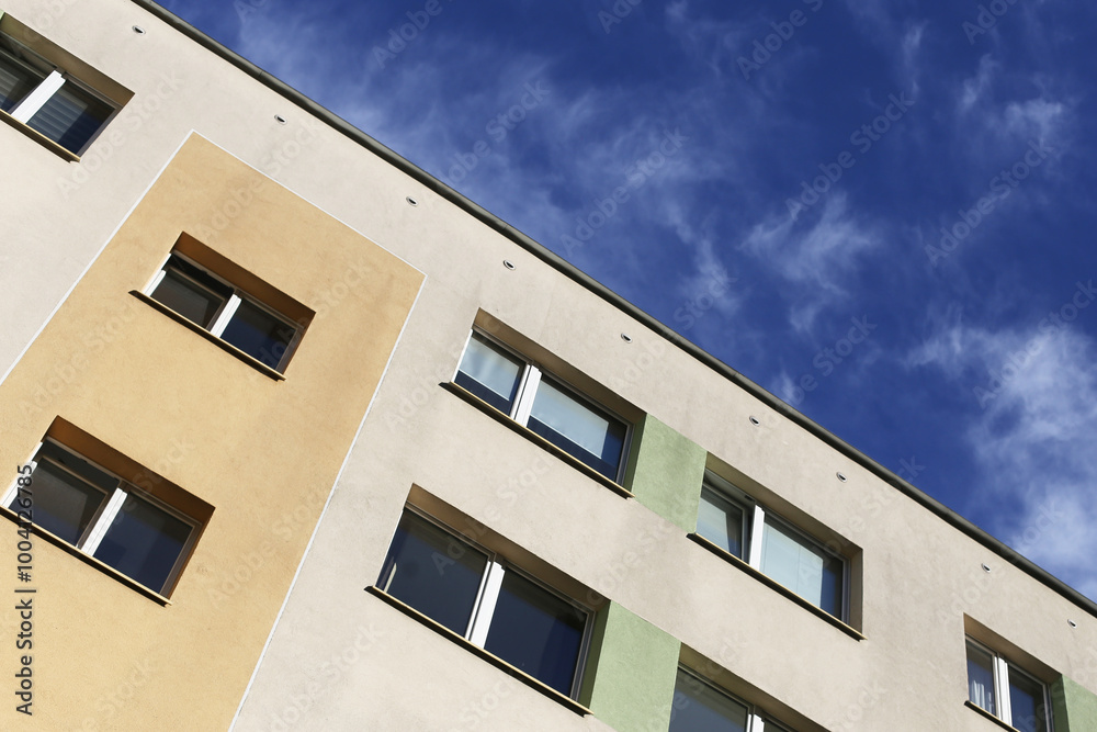Residential building in Poland against a blue sky. Housing background. Apartment in an old structure with a new facade and building insulation. Classic architecture in eastern Europe cityscape. Residential building in Poland against a blue sky. Housing background. Apartment in an old structure with a new facade and building insulation. Classic architecture in eastern Europe cityscape.