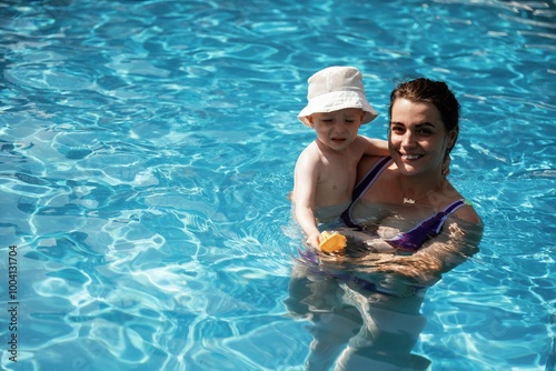 Happy mother with her little son are in the pool