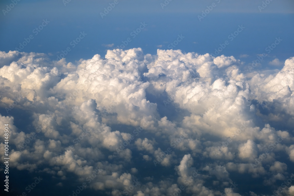 Cloudy sky, from airplane window point of view. View from above at high altitude of dense puffy cumulus clouds Cloudy sky, from airplane window point of view. View from above at high altitude of dense puffy cumulus clouds