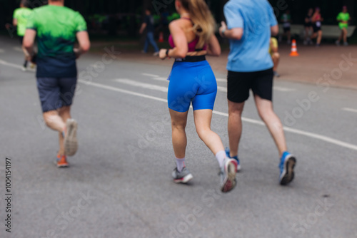 Marathon runners crowd, sportsmen participants start running the half-marathon in the city streets, crowd of sportswomen joggers in motion, group athletes outdoor training competition in a summer day photo