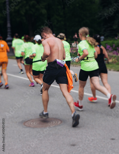 Marathon runners crowd, sportsmen participants start running the half-marathon in the city streets, crowd of sportswomen joggers in motion, group athletes outdoor training competition in a summer day