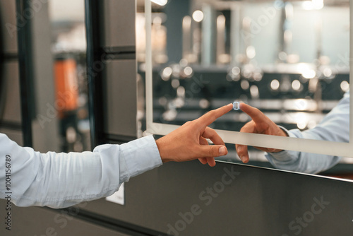 Close up view, touching smart mirror. Man is in the hardware shop photo