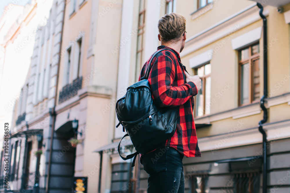 Fototapeta premium Anonymous man with backpack standing on street