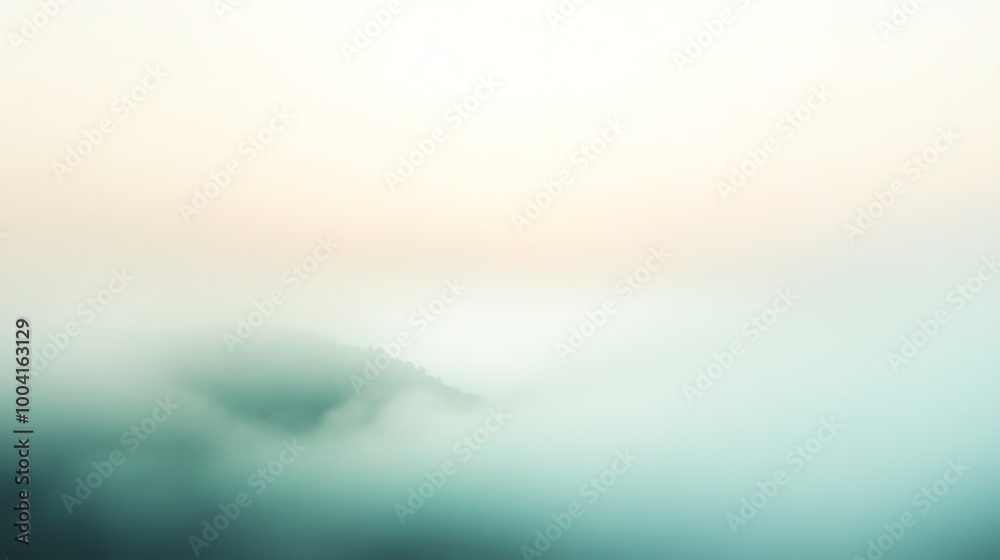 A hazy mountain range disappears into the clouds at sunrise.