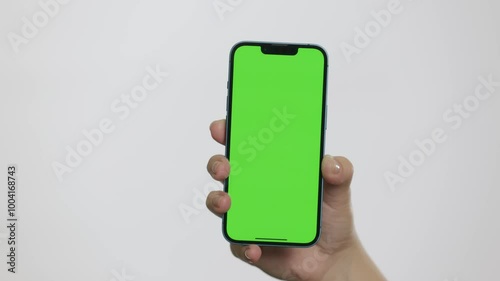 Close Up of Mobile Phone With Green Mock-up Screen In Women's Hands On White Background. Man Doing Swiping, Scrolling Gestures. Internet Social Networks Browsing News, Financial Reports	