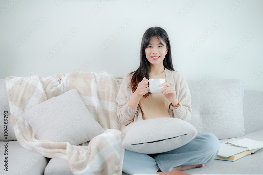 An Asian woman drinking coffee on a sofa. An Asian woman drinking coffee on a sofa.