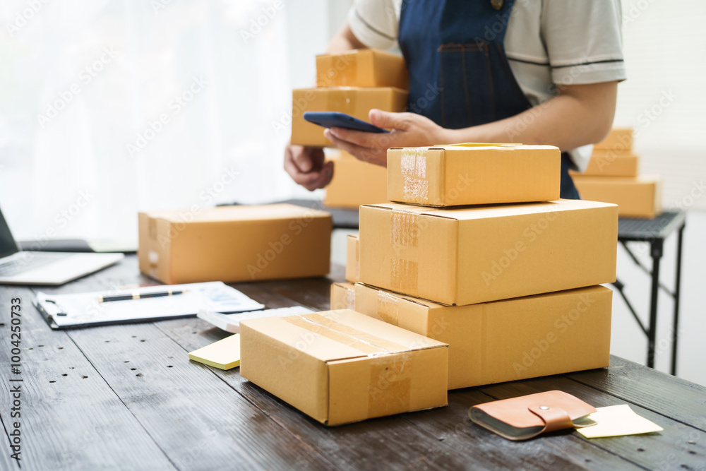 A man is working at his desk, preparing parcel boxes for shipment. He checks and packs items carefully, using shockproof materials, and attaches labels before sending them to customers via EMS. A man is working at his desk, preparing parcel boxes for shipment. He checks and packs items carefully, using shockproof materials, and attaches labels before sending them to customers via EMS.