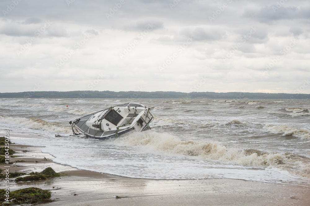 Denmark, Jutland, Fredericia, October 1, 2024. Storm on the coast with a sailboat that has torn itself from its moorings and is stranded on the beach.