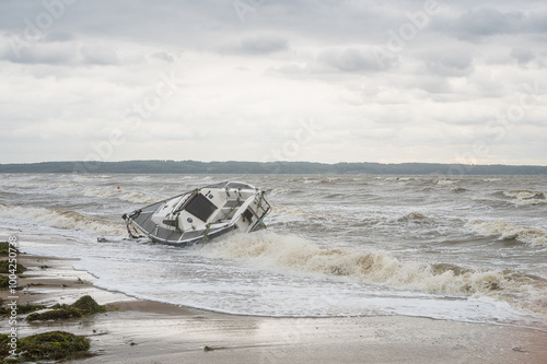Obraz na płótnie Denmark, Jutland, Fredericia, October 1, 2024. Storm on the coast with a sailboat that has torn itself from its moorings and is stranded on the beach. w salonie