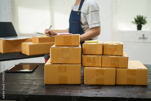 A man is working at his desk, preparing parcel boxes for shipment. He checks and packs items carefully, using shockproof materials, and attaches labels before sending them to customers via EMS.