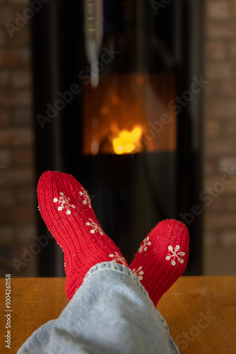 Woman warming herself in front of a pellet stove