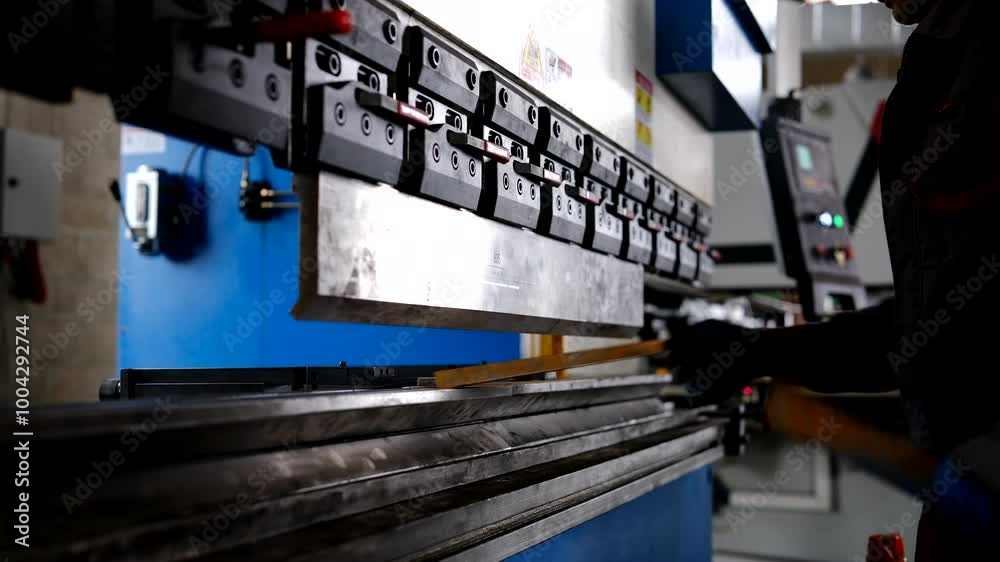 Man working with sheet metal on CNC hydraulic press brake. He puts the ...