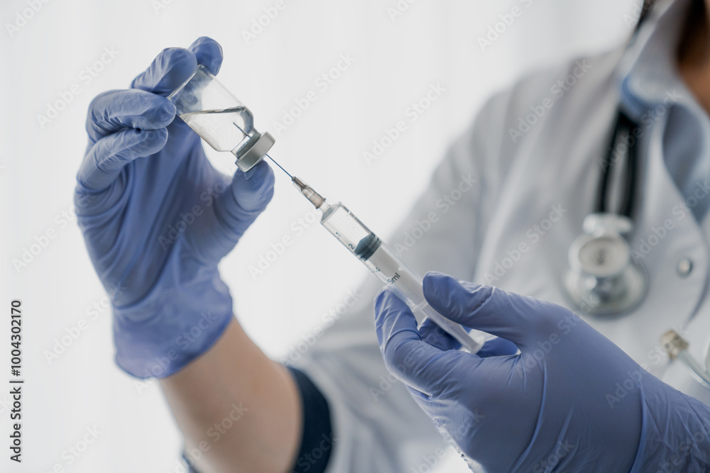 Medication nurse wearing protective gloves get a needle ready for an injection Medication nurse wearing protective gloves get a needle ready for an injection